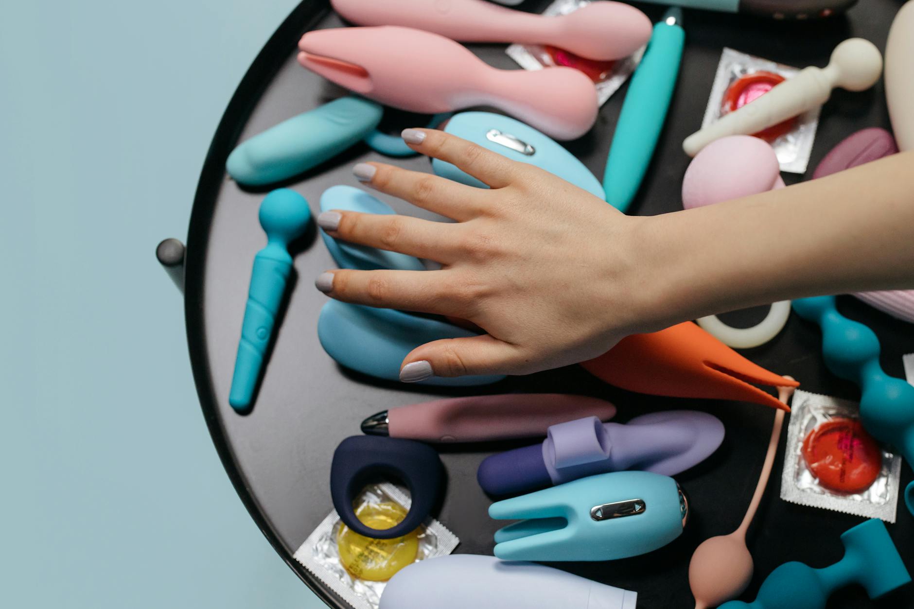 Hand holding a vibrator against a purple backdrop, showcasing modern sensuality and pleasure