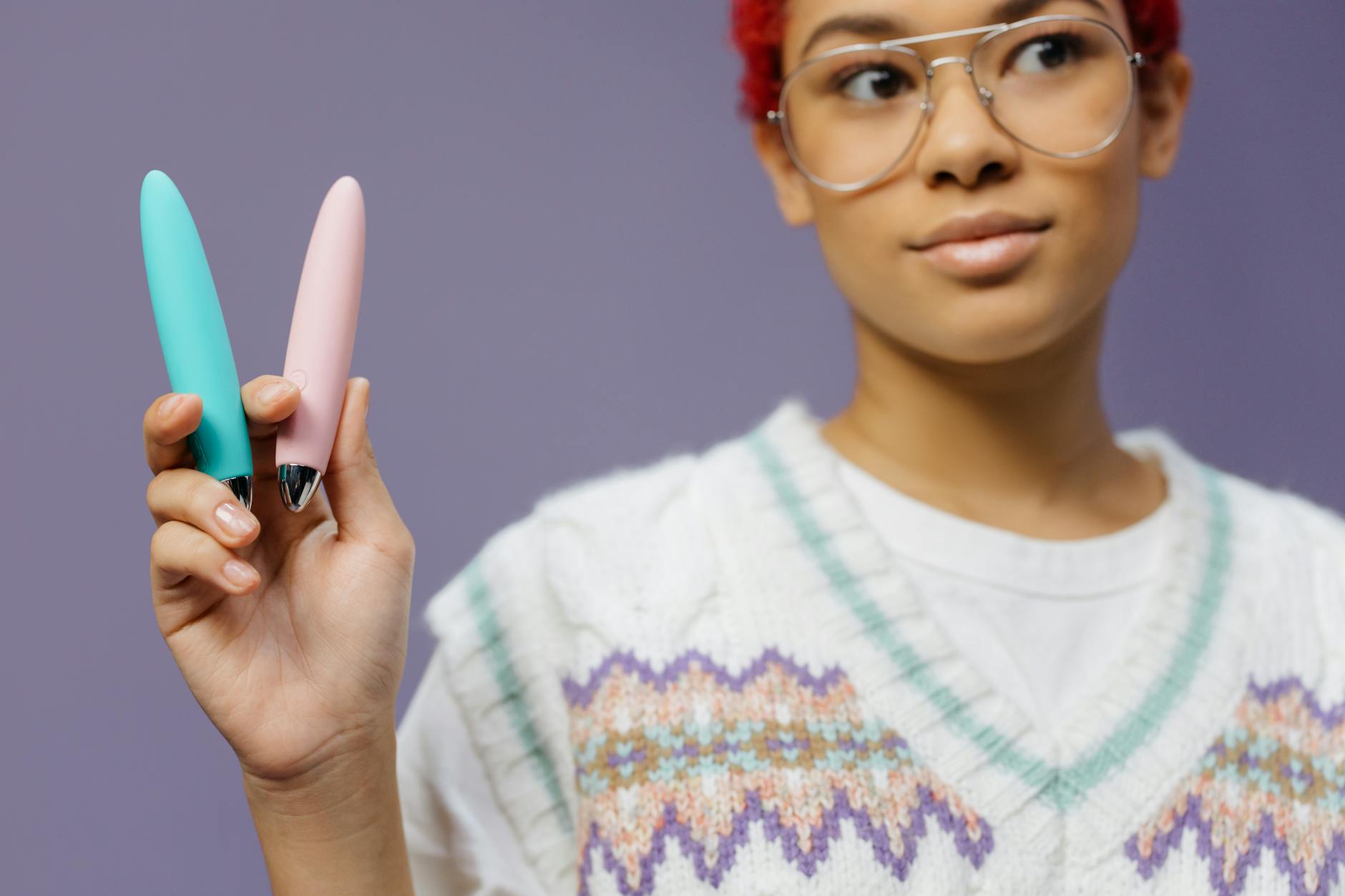 Two colorful vibrators held against a purple background, representing choice and exploration in solo play